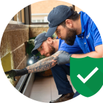Pest control experts inspecting a wall